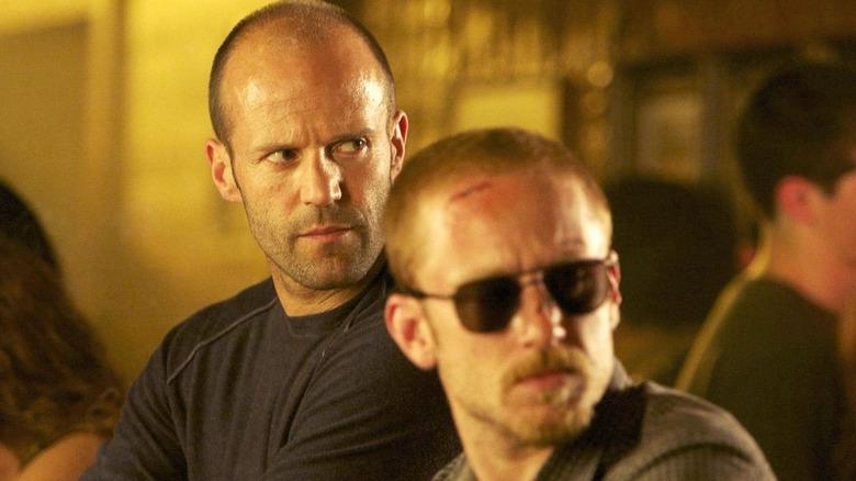 Jason Statham as Arthur and Ben Foster as Steve, staring at a dead man in The Mechanic