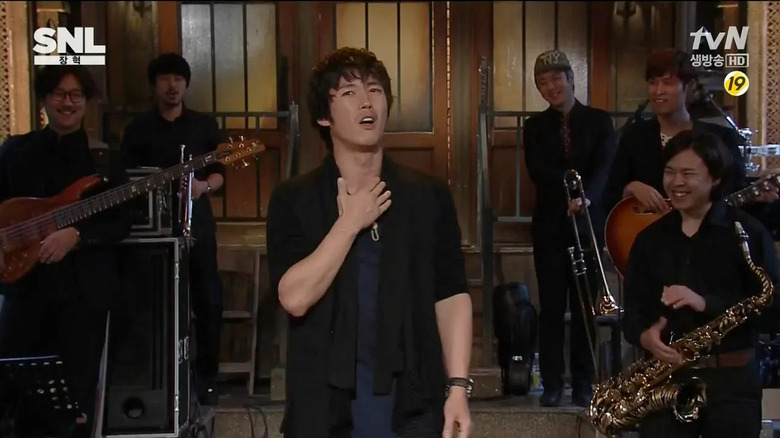 Jang Hyuk delivers a monologue before the house band in Saturday Night Live Korea