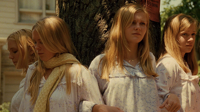 The Lisbon sisters link arms by a tree in The Virgin Suicides