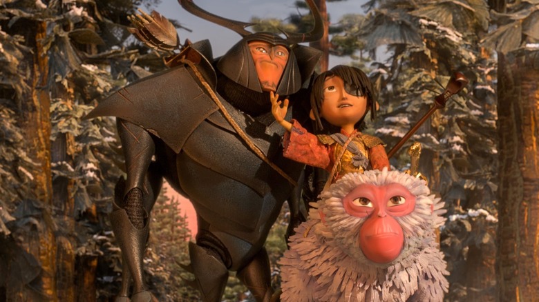 Kubo (Art Parkinson) gestures to the sky with Sariatu (Charlize Theron) and Hanzo (Matthew McConaughey) in Kubo and the Two Strings