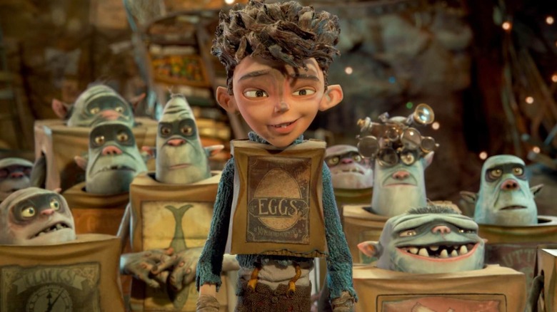 A dirtied Eggs (Isaac Hempstead Wright) stands in front of a group of Boxtrolls in The Boxtrolls