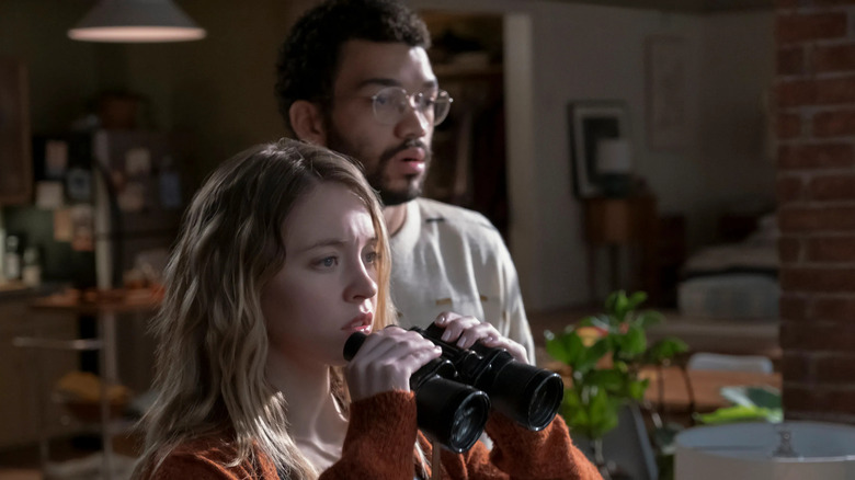 Sydney Sweeney as Pippa and Justice Smith as Thomas using binoculars in The Voyeurs