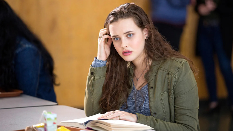 Hannah Baker (Katherine Langford) looks up from her book in the cafeteria in 13 Reasons Why