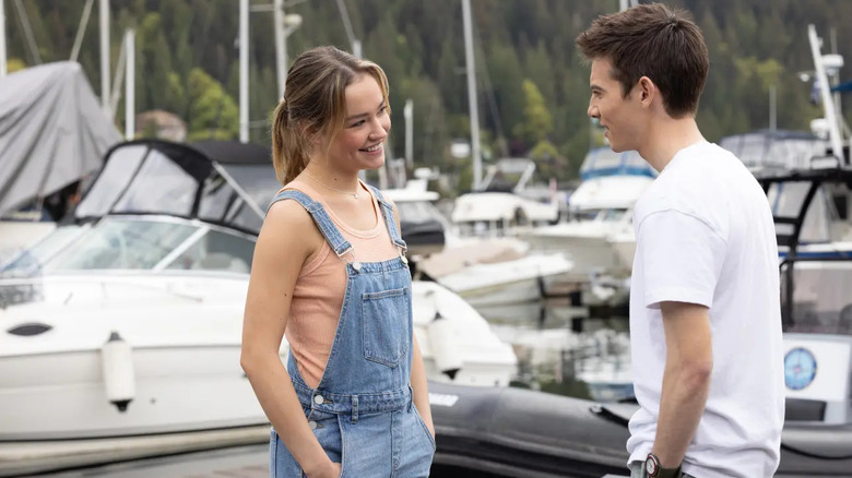 Megan Landry (Sadie Stanley) smiles at Luke Chambers (Griffin Gluck) by docked boats in Cruel Summer