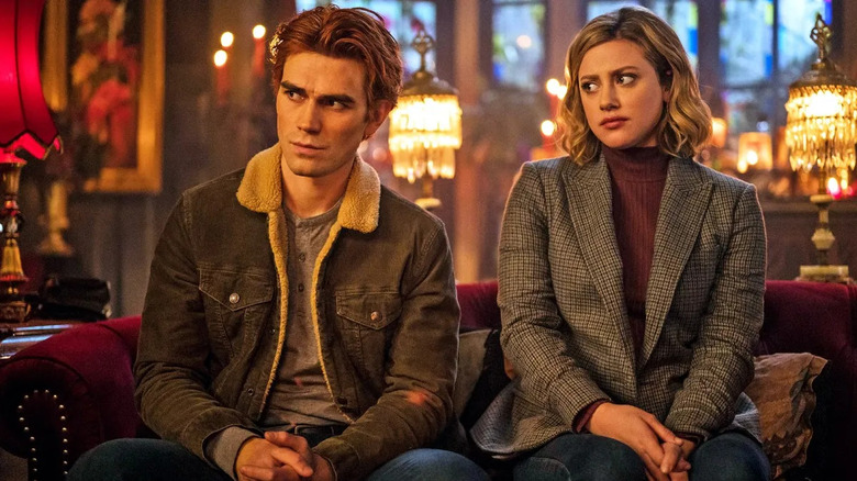 Archie Andrews (KJ Apa) and Betty Cooper (Lili Reinhart) sit on a couch in Riverdale