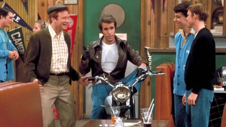 Fonzie (Henry Winkler) sits on his motorcycle in the diner on Happy Days