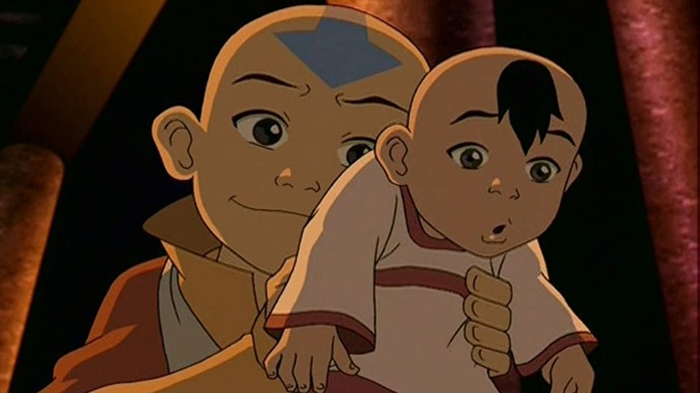 Aang holds a baby