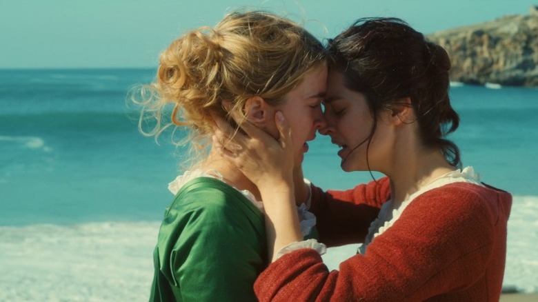 Adèle Haenel as Héloïse and Noémie Merlant as Marianne touching foreheads and embracing by the sea in Portrait of a Lady on Fire