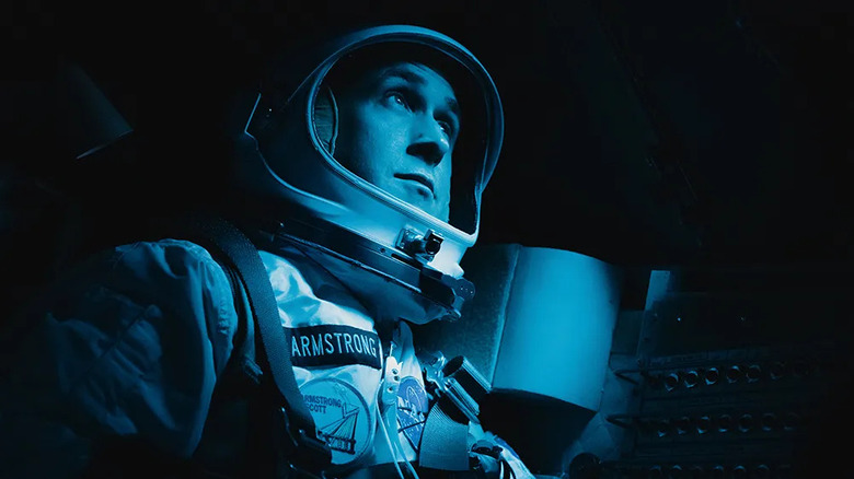 Ryan Gosling as Neil Armstrong sitting inside a dark spacecraft in First Man (2018)