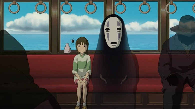 Chihiro and No-Face sitting together on a train in Spirited Away (2001)