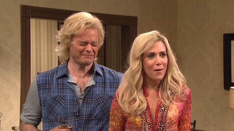Bill Hader and Kristen Wiig laughing in blonde wigs