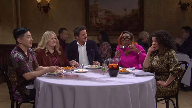 SNL cast members sitting at restaurant table