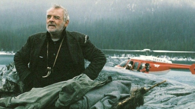 Charles Morse in front of a helicopter and mountains