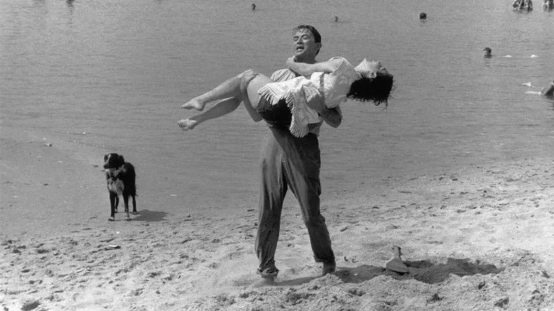 Man holding woman in arms in On the Beach