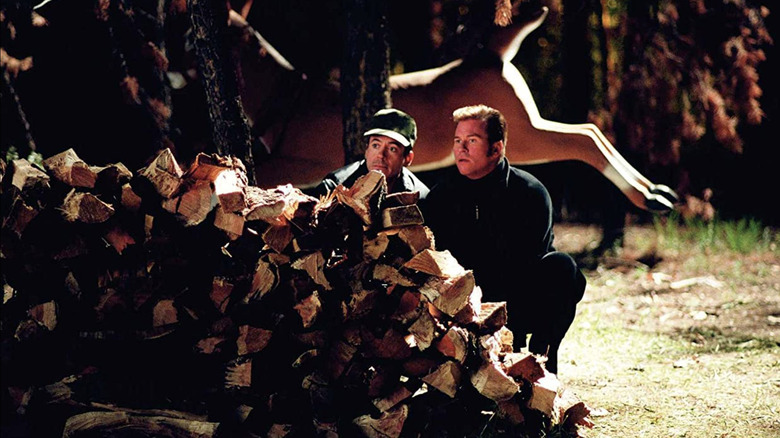 Harry Lockhart and Gay Perry hiding being stacked wood