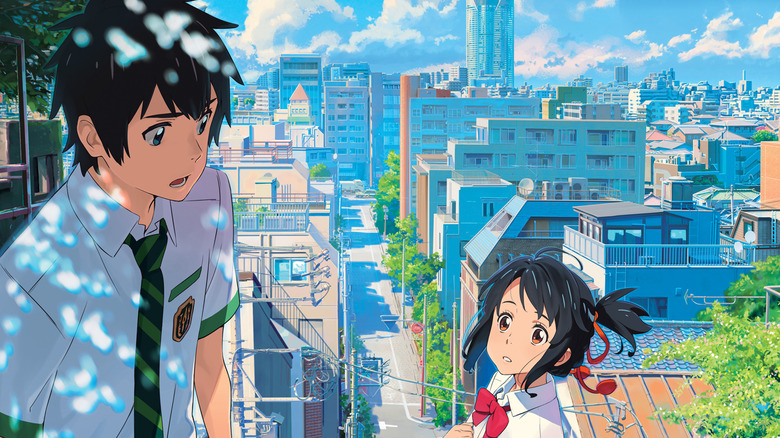 Teenage boy and girl look at each other against a cityscape