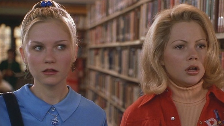 Kirsten Dunst and Michelle Williams standing in library in Dick