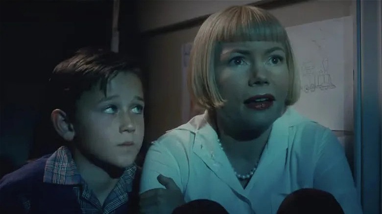 Michelle Williams sitting next to young boy in The Fabelmans