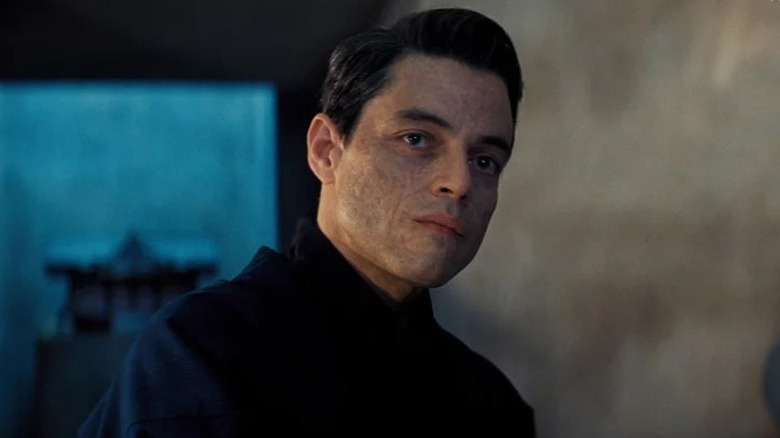 Rami Malek looking serious with scarred skin 