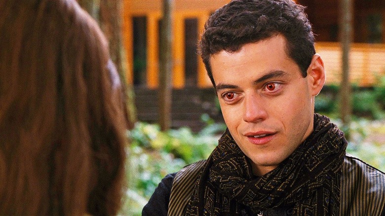 Red-eyed Rami Malek talking to someone