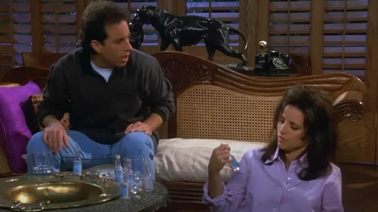 Jerry Seinfeld as Jerry watching Julia Louis-Dreyfus as Elaine drinking in Seinfeld