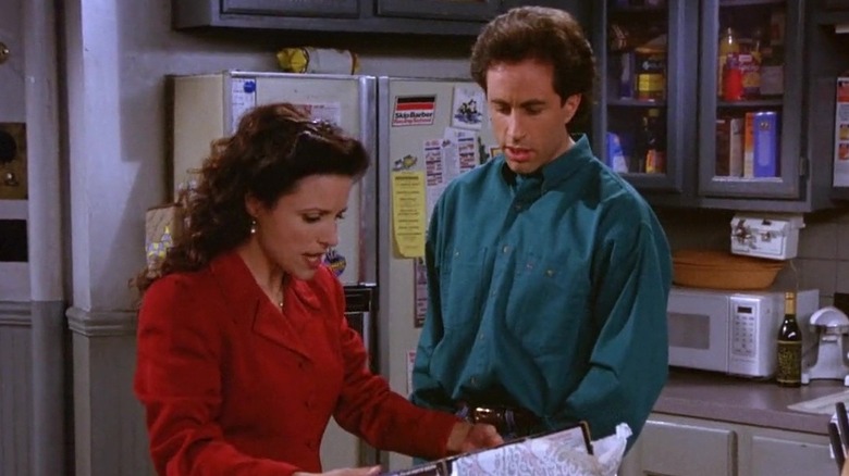 Julia Louis-Dreyfus as Elaine unwrapping a label maker in front of Jerry Seinfeld as Jerry in Seinfeld