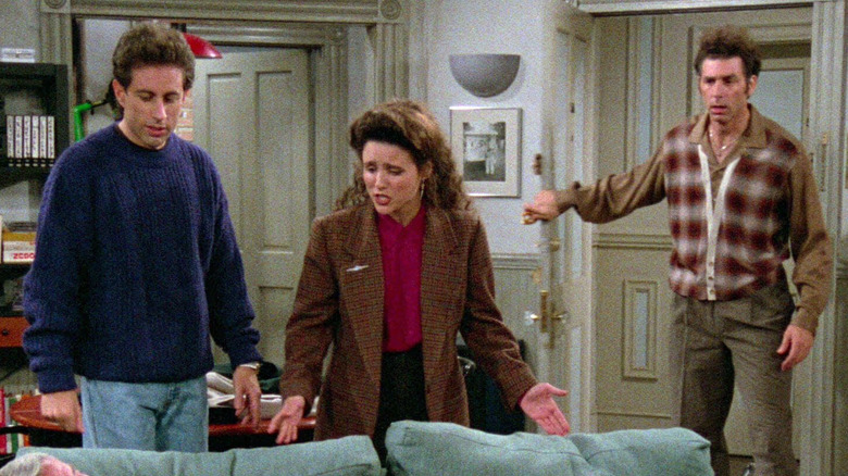 Jerry Seinfeld as Jerry, Julia Louis-Dreyfus as Elaine, and Michael Richards as Kramer staring at Jerry's couch in Seinfeld