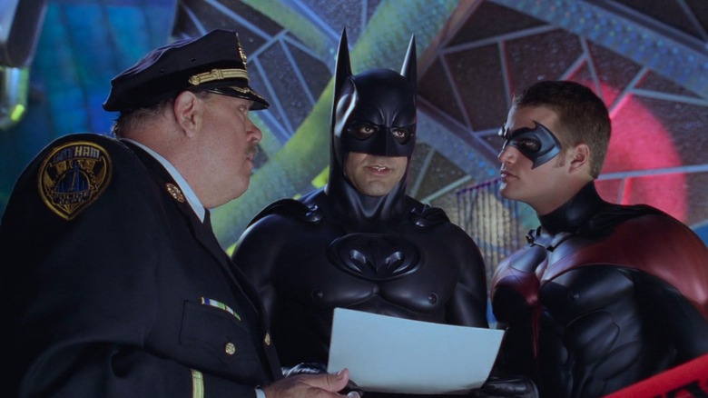 George Clooney and Chris O'Donnell as Batman and Robin, with a cop, against a colorful background