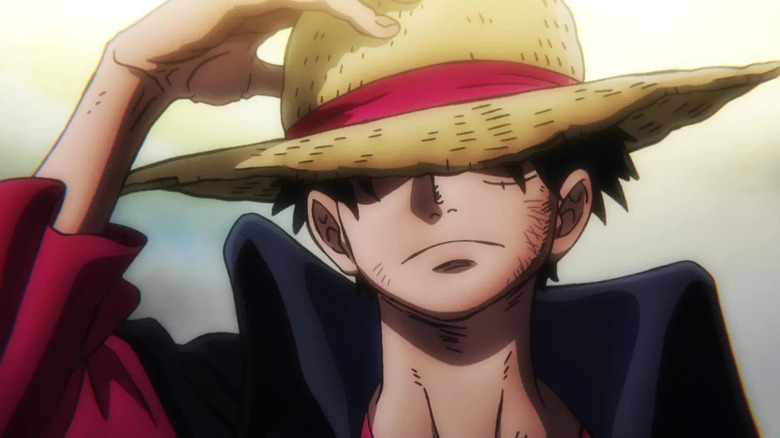 Luffy frowns while adjusting his hat on One Piece