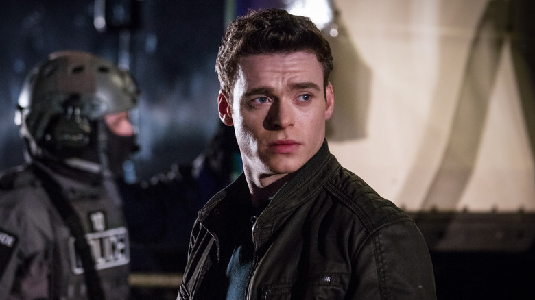 Richard Madden as David Budd, walking by a police officer in Bodyguard