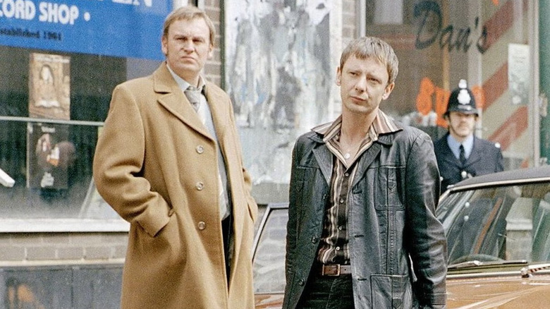 Phillip Glenister and John Simm as Gene Hunt and Sam Tyler standing near a car in Life on Mars