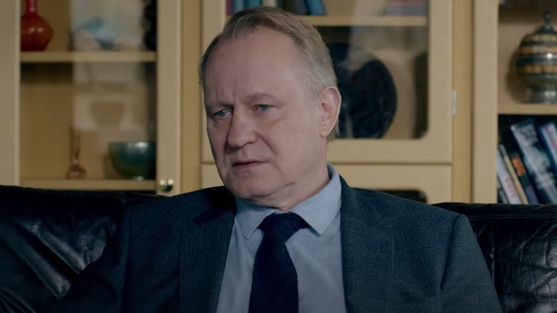 Stellan Skarsgård as John River, depressed on a couch in River