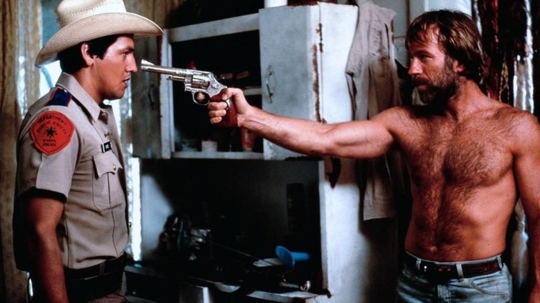 McQuade (Chuck Norris) points a gun at Kayo (Robert Beltran) in Lone Wolf McQuade