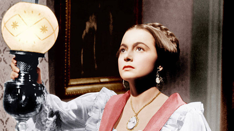 Olivia de Havilland holding lamp The Heiress