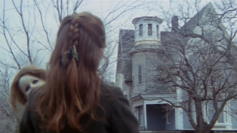 Mae (Silvia Collatina) looking at house in The House By the Cemetery