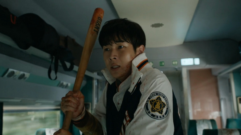 Yong-guk (Choi Woo-sik) looking scared while holding a bat in Train to Busan.