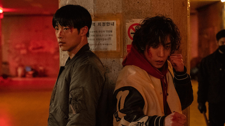 Kim Geun-woo (Woo Do-hwan) and Hong Woo-jin (Lee Sang-yi) stand bloodied and ready to fit in Bloodhounds