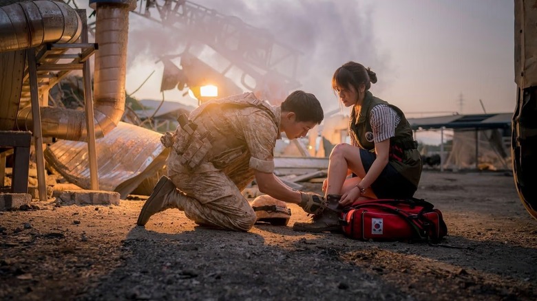 Yoo Si-jin (Soong Joong-ki) ties the shoe of Kang Mo-yeon (Song Hye-kyo) in Descendants of the Sun