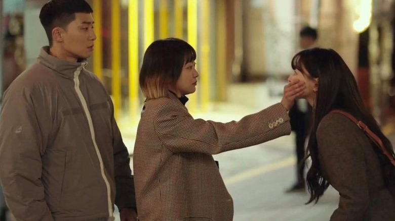 Park Sae-ro-yi (Park Seo-joon) watches Jo Yi-seo (Kim Da-mi) hold Oh Soo-ah (Kwon Nara) by the mouth in Itaewon Class