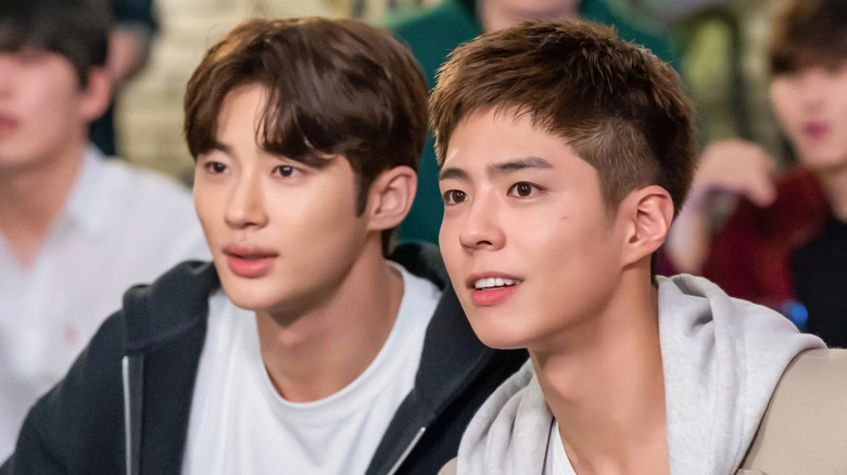 Won Hae-hyo (Byeon Woo-seok) and Sa Hye-jun (Park Bo Gum) stare intently at something off-screen in Record of Youth