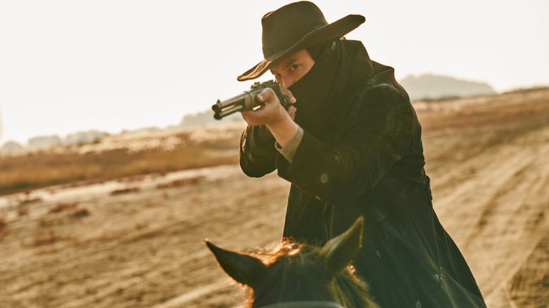 Lee Yoon (Kim Nam-gil) aims a rifle on horseback in Song of the Bandits