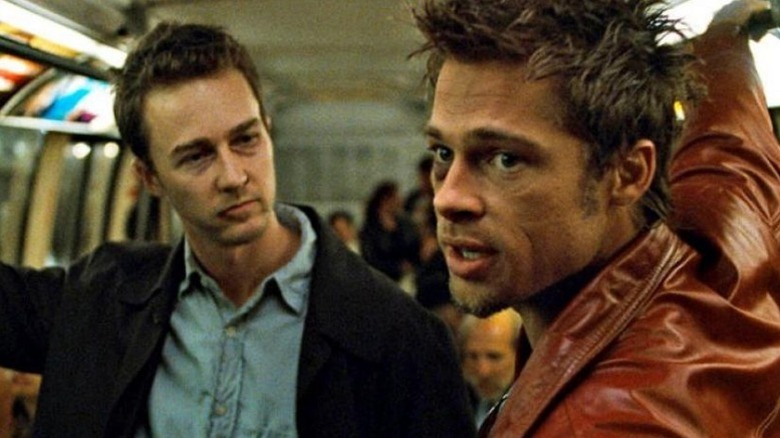 Edward Norton as the narrator and Brad Pitt as Tyler standing on subway in Fight Club.