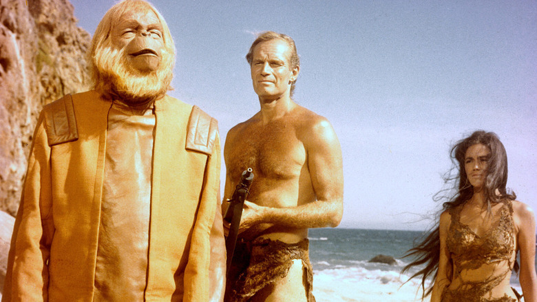 Maurice Evans as Dr. Zaius, Charlton Heston as George Taylor, and Linda Harrison as Nova on the beach in Planet of the Apes