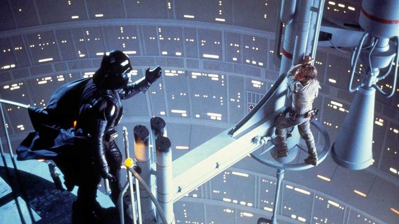 Luke (Mark Hammil) hanging from pole while Darth Vader reaches out to him in Empire Strikes Back.