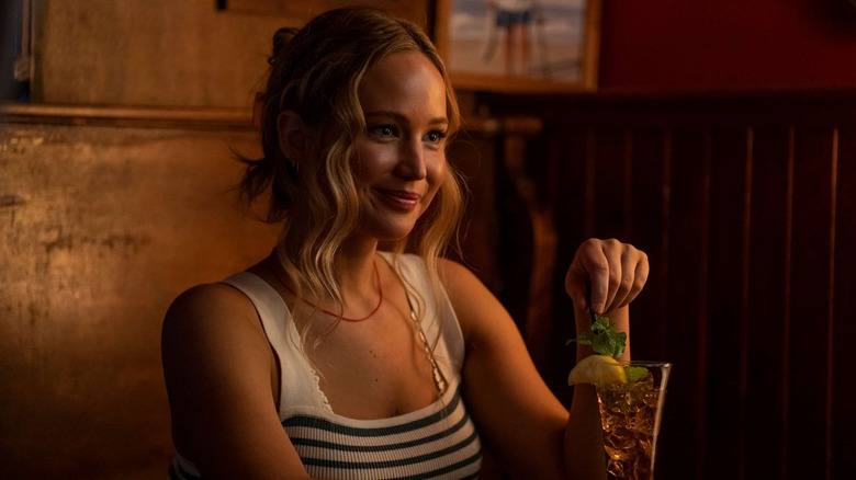 Jennifer Lawrence as Maddie in a booth with a drink in No Hard Feelings