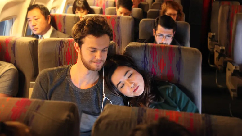 Maya Erskine as Alice sleeping against Jack Quaid as Benon on a plane in Plus One