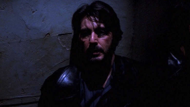 Carlito Brigante (Al Pacino) stands against a wall in the shadows in Carlito's Way