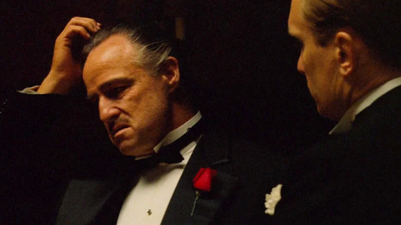 Vito Corleone (Marlon Brando) scratches his head in front of Tom Hagen (Robert Duvall) in The Godfather