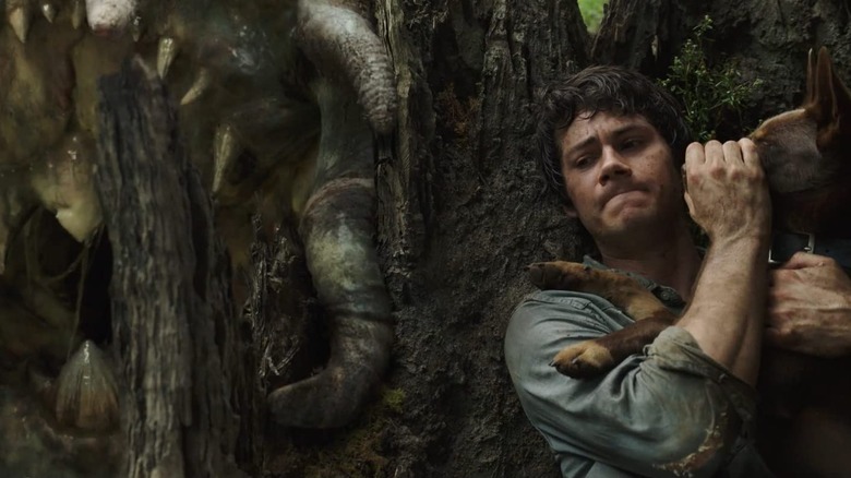 Joel (Dylan O'Brien) hiding from a beast in Love and Monsters