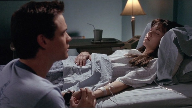 Mandy Moore as Jamie Sullivan holds the hand of Shane West as Landon Carter in A Walk to Remember